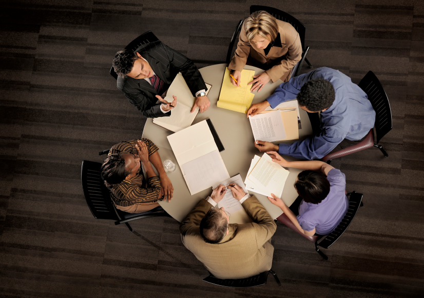 Six people at round table meeting shot from above